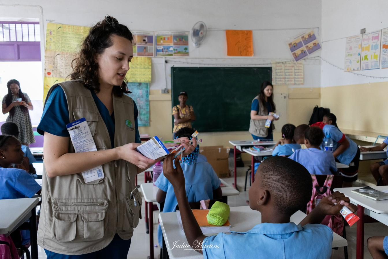 Voluntaria repartiendo kits de higiene oral a un niño