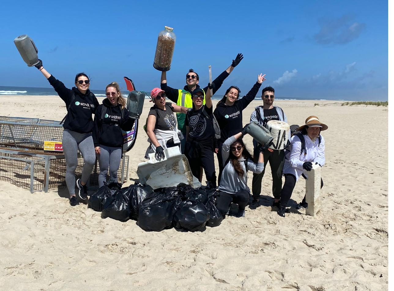 Voluntarios celebrando con bolsas de basura recogida en la playa